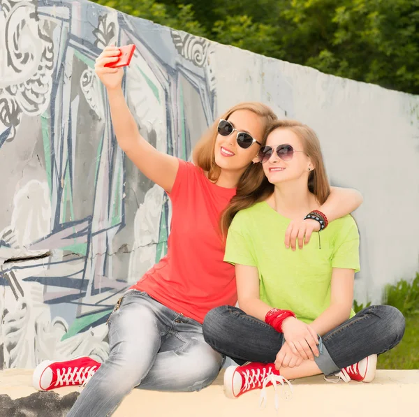 Portret van twee tienermeisjes vrienden in hipster outfit met f Stockafbeelding