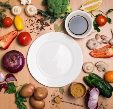 Rustik ahşap masa etrafında boş tabak yemek pişirmek için renkli maddeler.