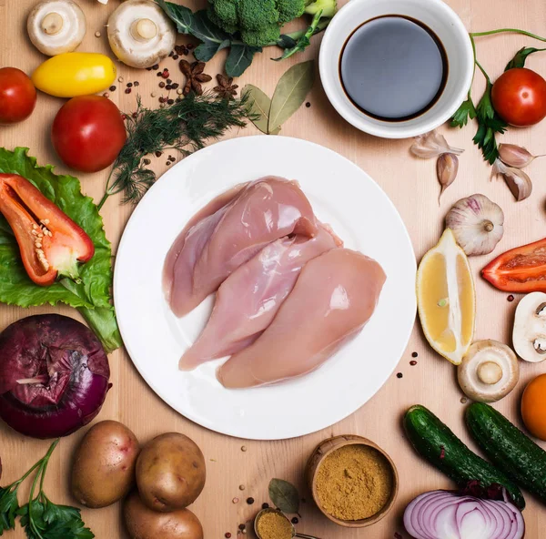 Filete de pollo crudo. Carne fresca de pollo en plato blanco sobre madera — Foto de Stock