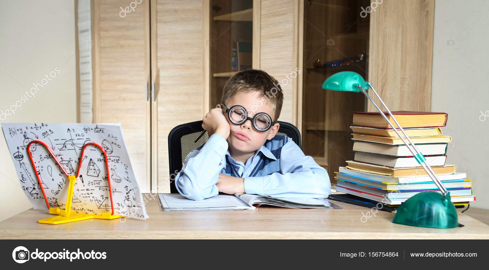 Müder Junge mit lustiger Brille bei den Hausaufgaben. Kind ...