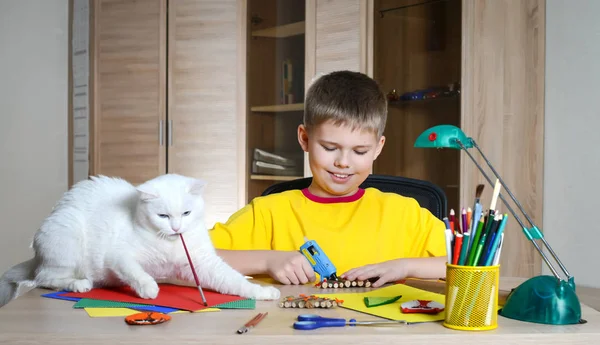 Child making Christmas decorations with cat on the table. Make c — Stock Photo, Image