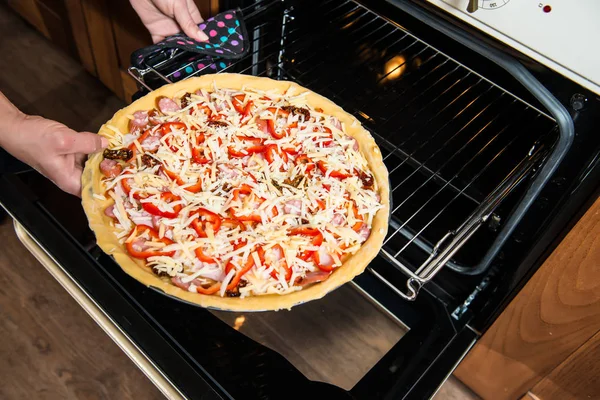 Pizza fresca fatta in casa che cuoce nel forno elettrico . Fotografia Stock