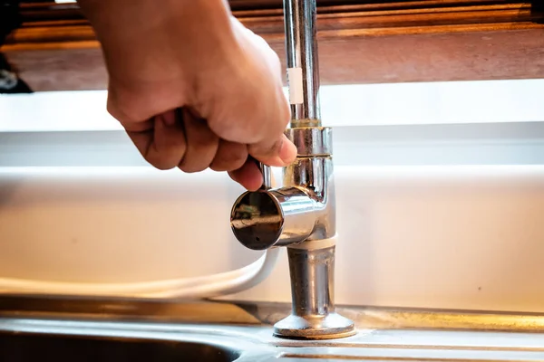 Hand opening a water faucet — Stock Photo, Image