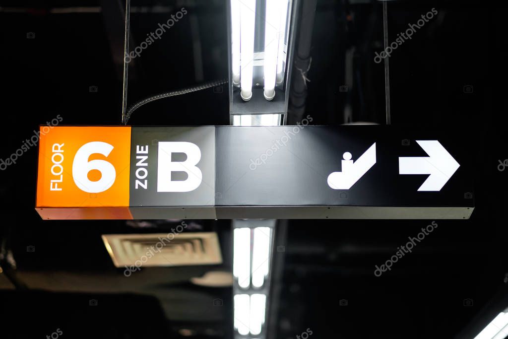 A directional signboard, indicating floor number, zone, elevator and toilet direction