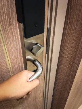 Bir el ahşap kapıyı açmak için alüminyum kapı topuzunu çevirdi.