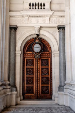 An antique wooden door with roman architecture 