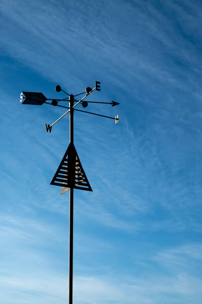 An isolated traditional metal weather vane with beautiful sky and clouds backfground