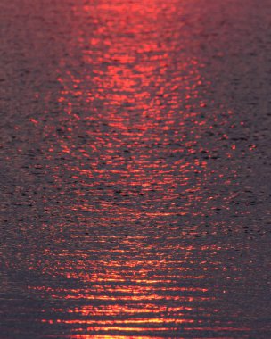 Denizde gün batımından gelen kırmızı su dalgaları