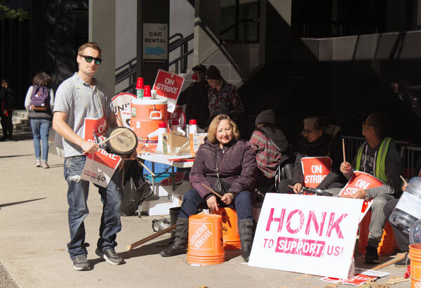 Ванкувер, Канада - 27 сентября 2019 года: Активисты сидят на улице Гастингс перед отелем Pinnacle. Забастовка работников гостиничного комплекса в центре Ванкувера
