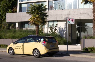Vancouver, Kanada - 5 Ekim 2019: A Black Top Cabs taksisinin yakın çekimi Vancouver şehir merkezindeki duraksız tabelanın etrafındaki yolcuyu bekliyor