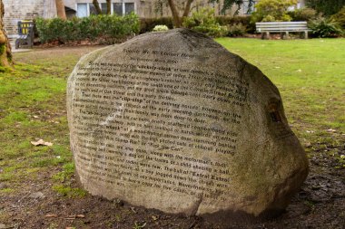 Vancouver, Canada - February 17, 2020:A huge rock with a poem inscribed on it on the back lawn of the Vancouver City Hall by Ina Trudge on March 2000