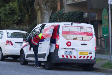 Vancouver, Canada - February 20, 2020: A Canada Post employee sorts packages inside the Canada Post Van in Downtown Vancouver