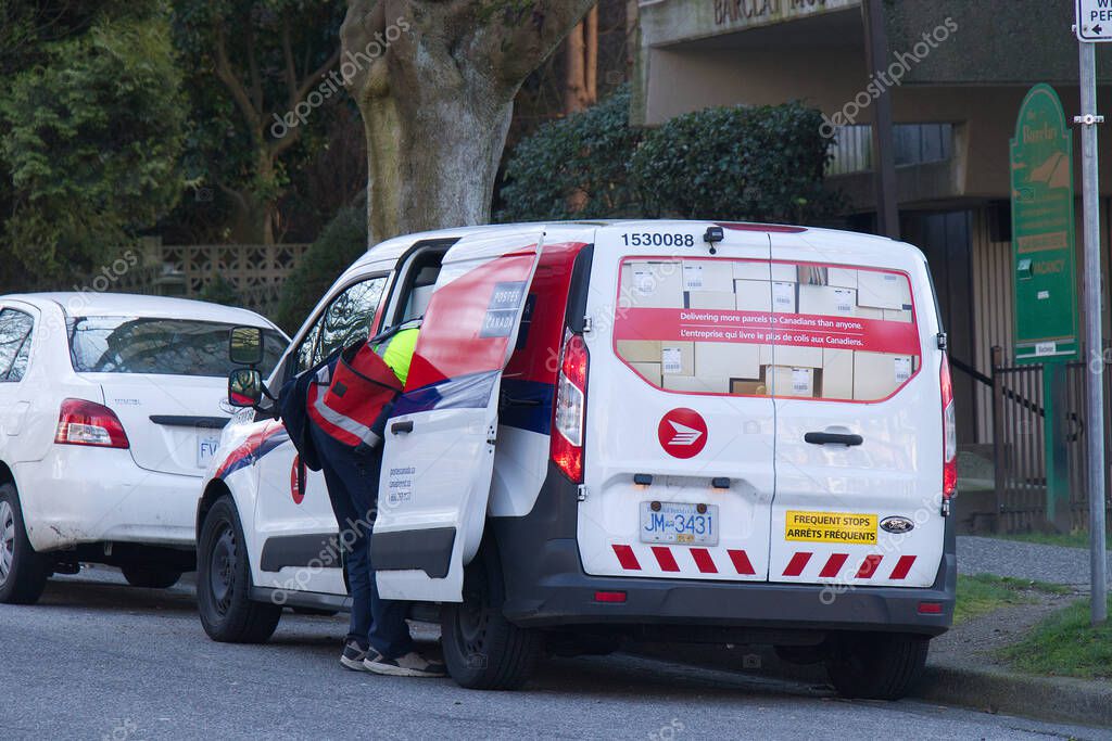 Vancouver, Canada - February 20, 2020: A Canada Post employee sorts packages inside the Canada Post Van in Downtown Vancouver