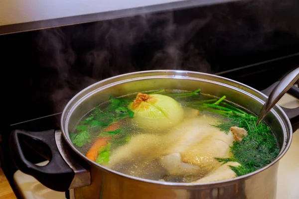 Whole chicken soup with vegetables in a pot. — Stock Photo, Image