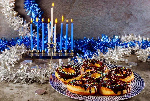 Yahudi bayramı bayramı. Yanan mumlarla menorah ve üstüne çikolata serpiştirilmiş tatlı çörekler.. — Stok fotoğraf