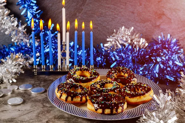 Yahudi bayramı bayramı. Yanan mumlarla menorah ve üstüne çikolata serpiştirilmiş tatlı çörekler.. — Stok fotoğraf
