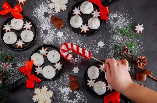 Noel süslemeleri ve pudra şekerli çörekler. Çocuklar masadan şeker alıyor.. — Stok fotoğraf