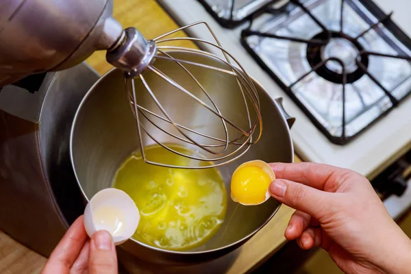 A woman separates egg white from yolk to make a sponge cake.