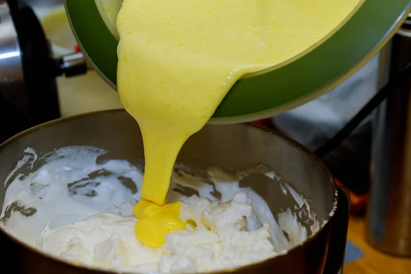 Adding whipped egg yolks in whipped egg white. — Stock Photo, Image