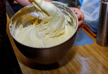 Karıştırma kabında yumurta, şeker ve unu karıştıran kadın. Pasta hamuru..