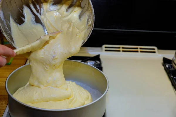 Pouring fluffy dough into round baking pan. — Stock Photo, Image