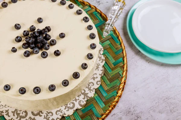 Pastel blanco festivo con arándanos frescos sobre un fondo blanco . — Foto de Stock