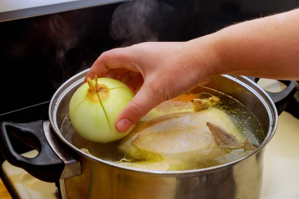 Οι γυναίκες βάζουν κρεμμύδι στο ζωμό. Κοτόσουπα στην κατσαρόλα. — Φωτογραφία Αρχείου