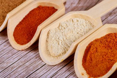 Paprika tozu, ahşap arka planda ahşap kepçelerde sarımsak. Kapat..