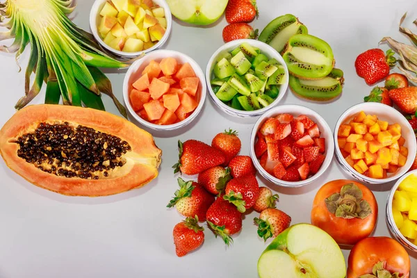 Υγιή φρούτα. Παρασκευή σαλάτας από παπάγια, φράουλα, μήλο, ανανά, ακτινίδιο και λωτό. — Φωτογραφία Αρχείου