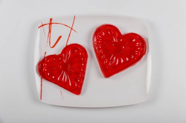 Beyaz tabakta çilek jelatininden yapılmış iki kalp..