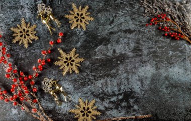 Ren geyikleri, kar taneleri ve kırmızı böğürtlenli Noel arkaplanı.