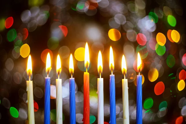 Menora mit brennenden Kerzen für Chanukka auf glitzerndem Hintergrund mit defokussiertem Licht. — Stockfoto