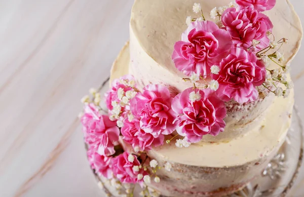 Hochzeit nackte Torte mit rosa Blumen Nahaufnahme dekoriert — Stockfoto