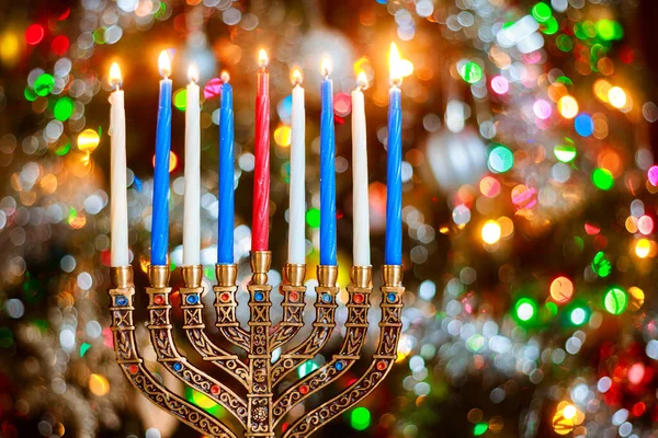 Menorah med brinnande ljus för Hanukkah på glitter bakgrund med defocused ljus. — Stockfoto