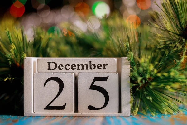 25 december op houten kubus met kerstboom verlichting achtergrond. Kerstconcept — Stockfoto