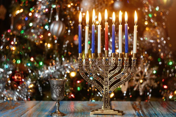 Hanukkah background with menorah and burning candles on sparkle background with defocused lights. — ストック写真