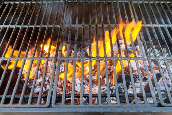 Flames goes through grid of barbecue grill — Stock Photo, Image