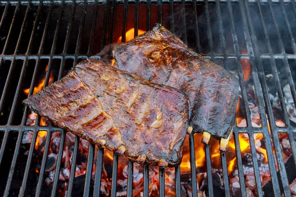 Costillas de ternera de repuesto en parrilla BBQ con llama —  Fotos de Stock