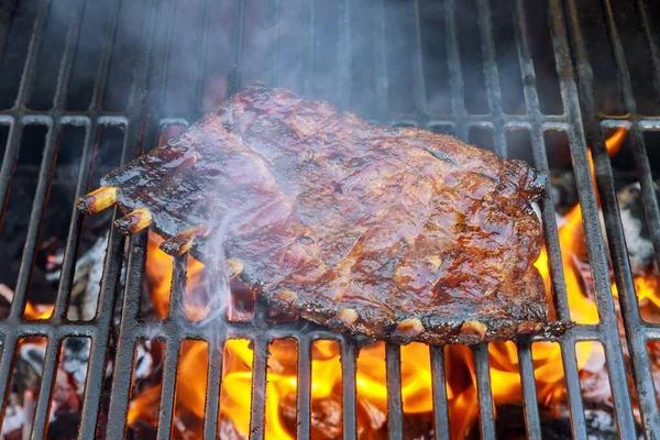 Costillas asadas en la parrilla de llama caliente . —  Fotos de Stock