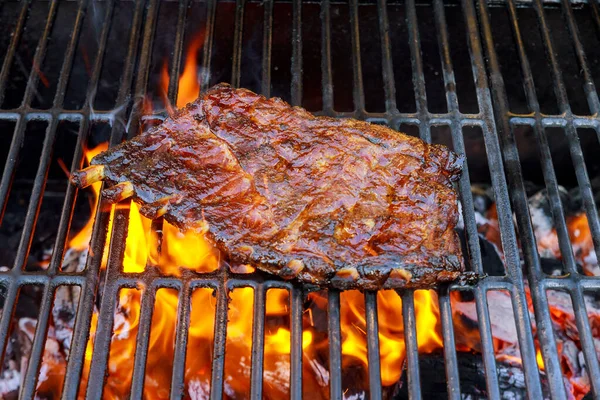Smoked spare ribs on the flaming charcoal grill