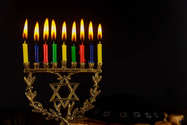 하누카를 위한 촛불을 켜고 유대인의 휴일을 배경으로 반짝이는 검은 배경 위에 메노라. — 스톡 사진