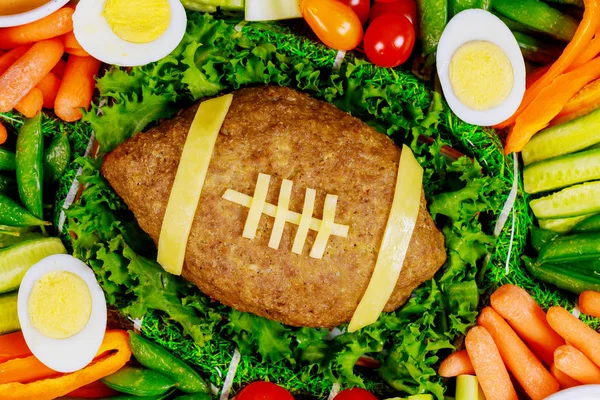 Prato vegetal colorido com rolo de carne como uma bola de futebol para a festa de futebol americano. Fechar . — Fotografia de Stock