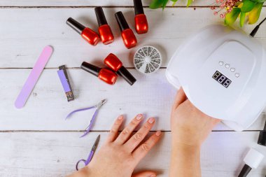 Kadın akrilik manikür yapmak için Led Lambası 'na elini sokuyor..