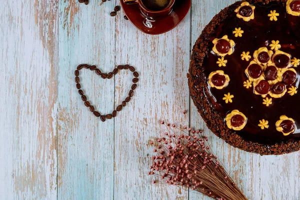 Bentuk hati yang terbuat dari biji kopi dengan kue ceri cokelat . — Stok Foto