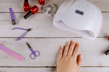 Kadın lambayla güzel akrilik manikür yapıyor..