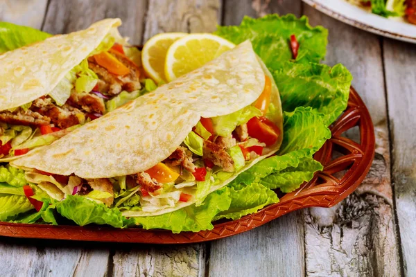 Мягкие лепешки, фаршированные салатом, мясом и сыром на деревянном фоне. Мексиканская кухня . — стоковое фото