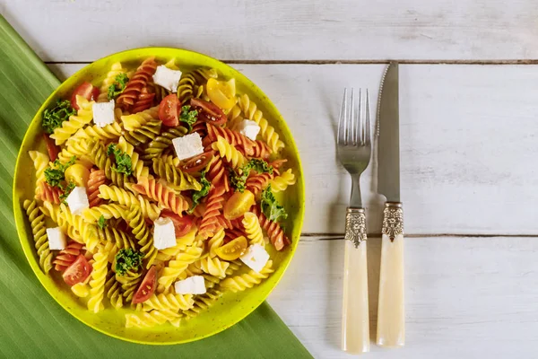 Italian colorful pasta rotini with cherry tomatoes on white wooden background. — Stock Photo, Image