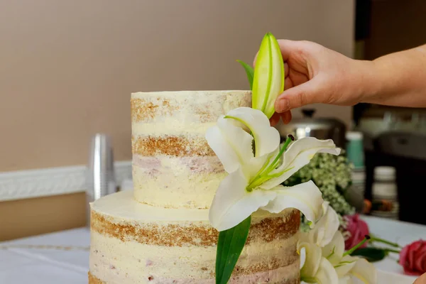 Frau dekoriert nackten Kuchen mit Blumen. — Stockfoto