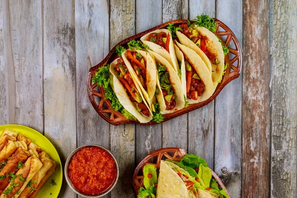 Taquitos, weiche Tortillas und Salsa auf Holztisch. — Stockfoto