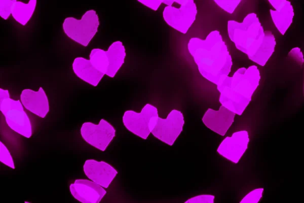 Coração rosa desfocado molda bokeh no fundo preto. Conceito de dia dos namorados . — Fotografia de Stock